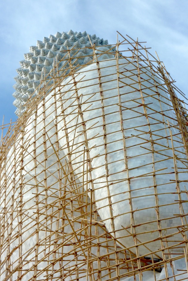 Eine Buddha-Statue wird mit Bambus Gerüstbau gewartet